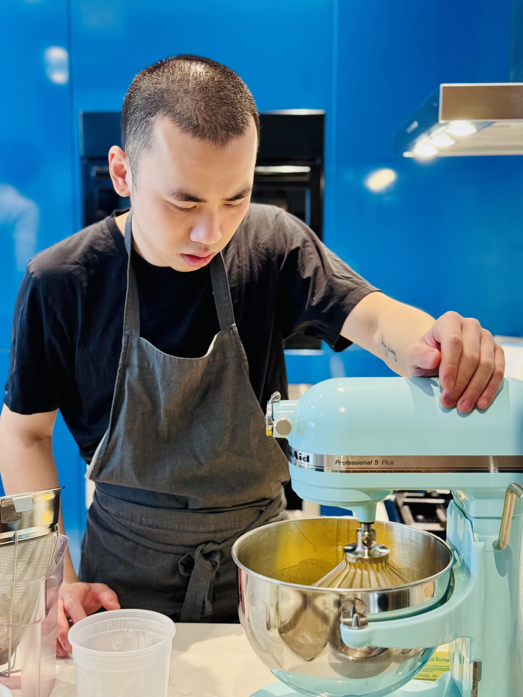 Chef Desmond Ho working a stand mixer in a test kitchen