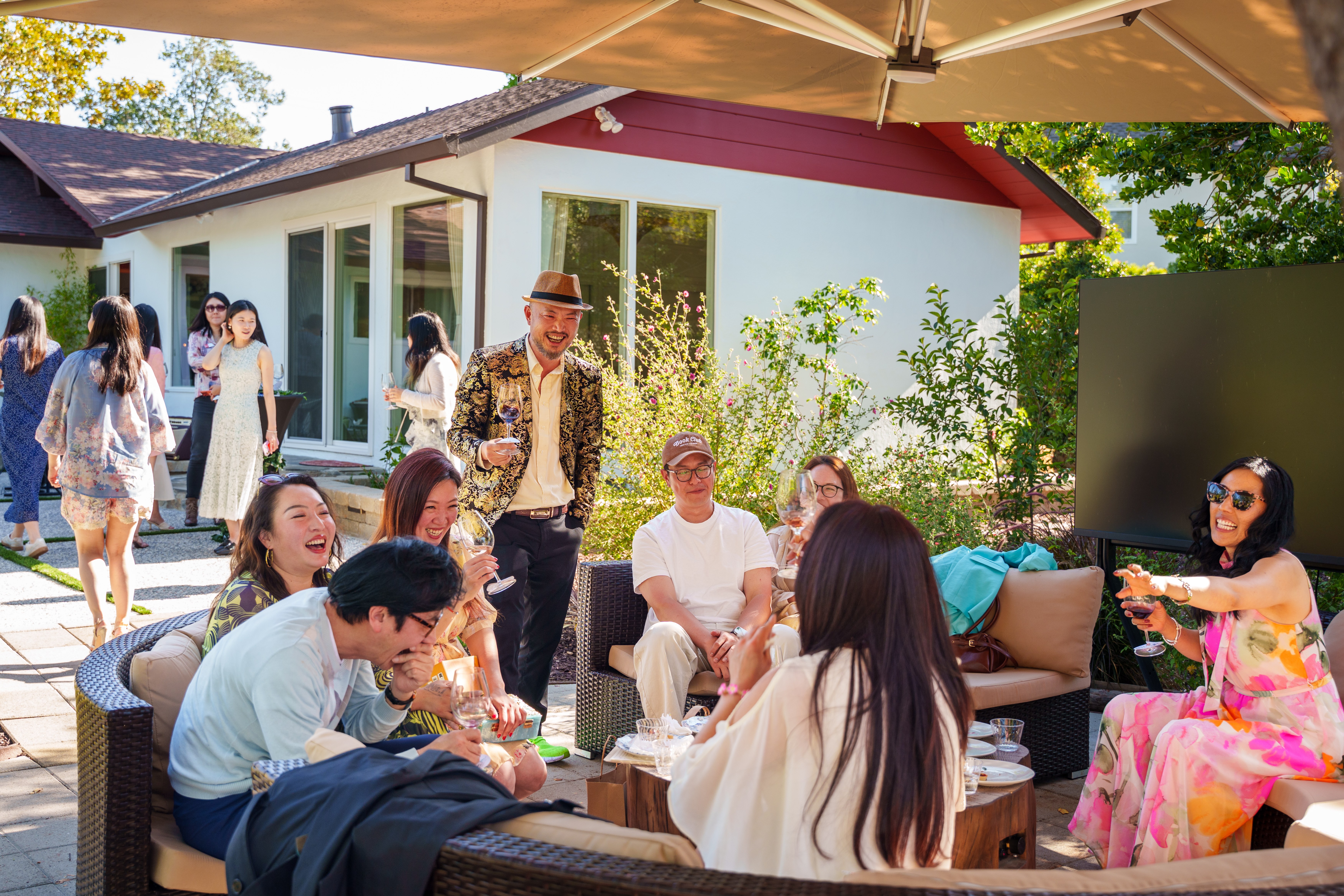 Guests mingling outdoors with wine glasses at a private La Rizière event