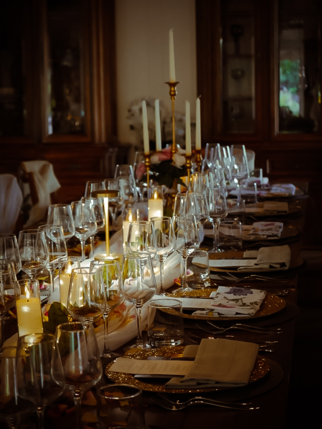 A long candlelit dining table set with crystal glasses and floral centerpieces at the Cupertino dinner