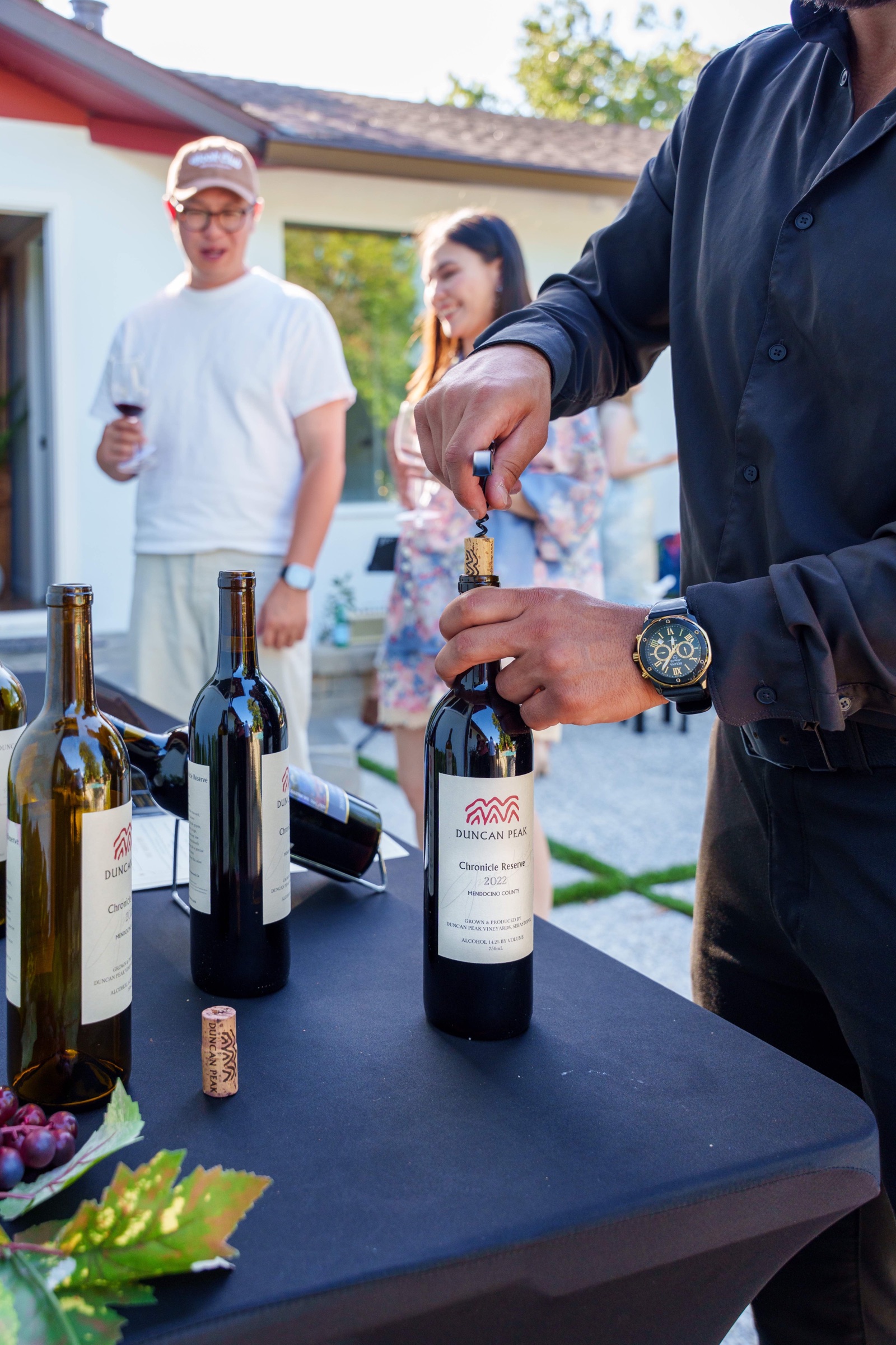 A bottle of Duncan Peak wine being opened tableside at a private dinner